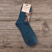 Pair of McMoo Highland Cow Socks in fresh green, adorned with an exquisite Highland cow design by artist Jennifer Hogwood.